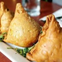 Samosa · Golden-fried flaky pastry puffs, stuffed with potatoes, peas, spices served with tamarind ch...