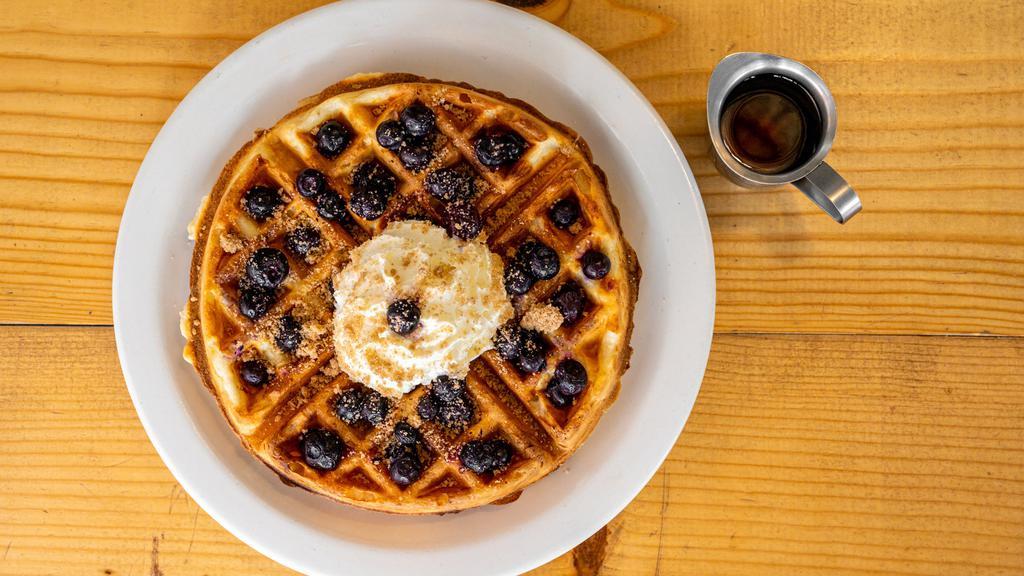 Cobbler Waffle · Belgian waffle with blueberries, streusel and whipped cream. Served with maple syrup and homemade whip cream.