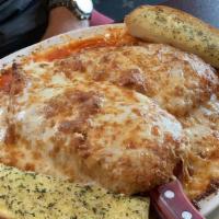 Chicken Parmesan · 2 breaded chicken breasts baked on a bed of spaghetti with our homemade marinara sauce and t...