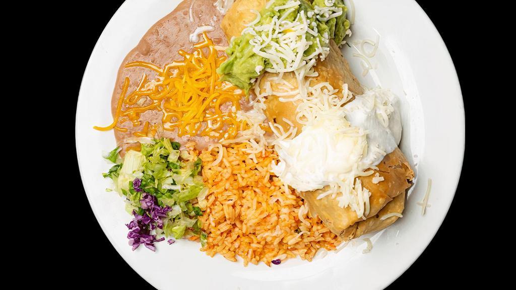 Chimichanga · Meat & beans wrapped in a flour tortilla, deep fried, topped w/ sour cream, cheese & guac, rice & beans