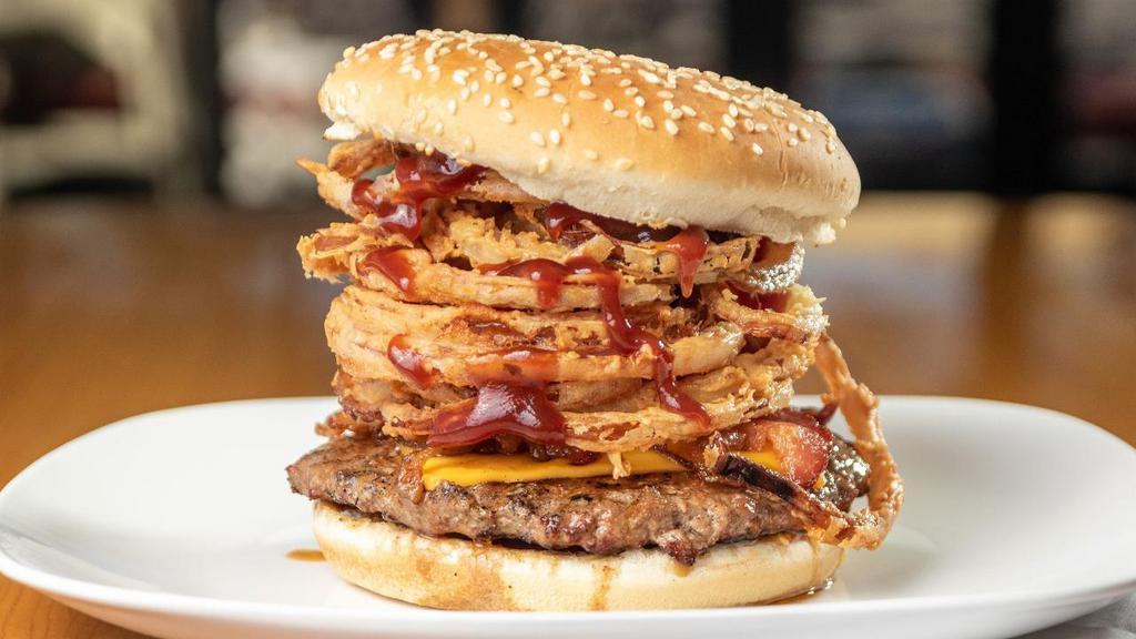 Cowboy Cheeseburger · 1/3 lb. Ground Chuck Patty Mesquite-Fired on a Toasted Bun, w/ BBQ Sauce, Apple-Wood Smoked Bacon, Pickles, and Deep Fried Onion Strings. Topped With American Cheese.