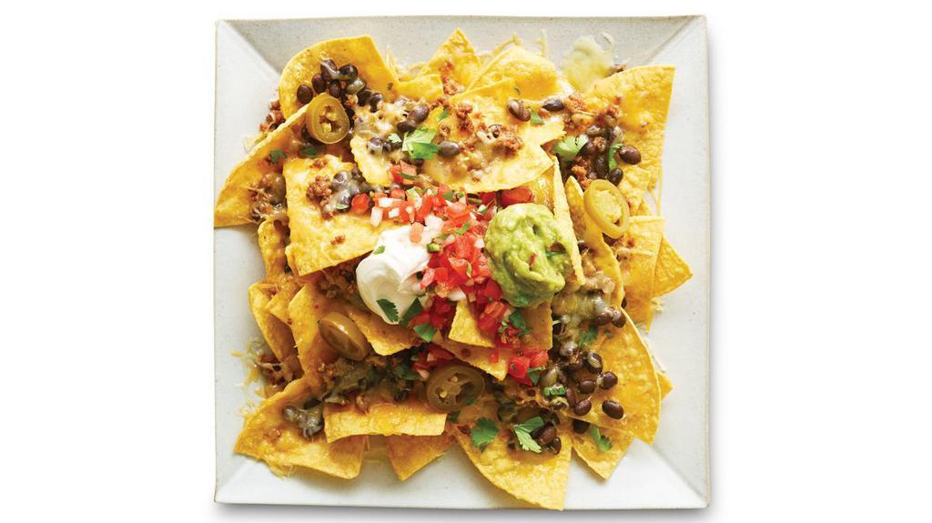 Loaded Nachos · Chips, shredded cheese or yellow queso, refried, black, or pinto beans, choice of protein, pico de gallo, sour cream, and guacamole. 1040 cal.