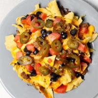 Nachos · Tortilla chips smothered in Cheddar arid Monterey jack cheese, roasted jalapenos, black bean...