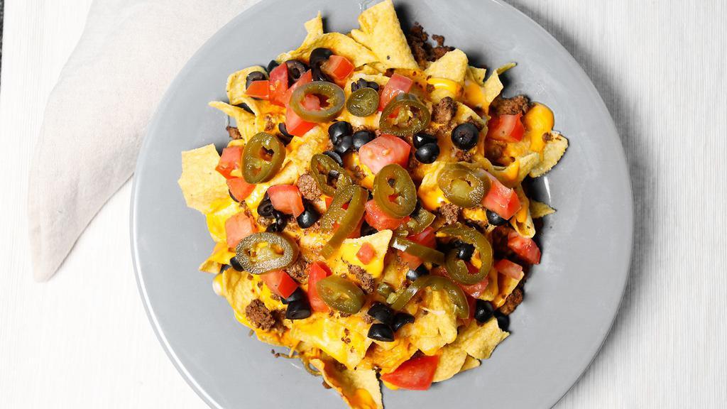 Nachos · Tortilla chips smothered in Cheddar arid Monterey jack cheese, roasted jalapenos, black beans, guacamole and sour cream.