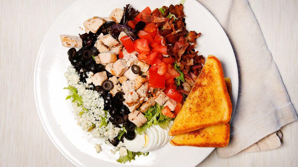 Cobb · Grilled chicken, Bleu cheese crumbles, bacon, hard-boiled eggs, tomato and black olives over spring. Served with your choice of dressing.