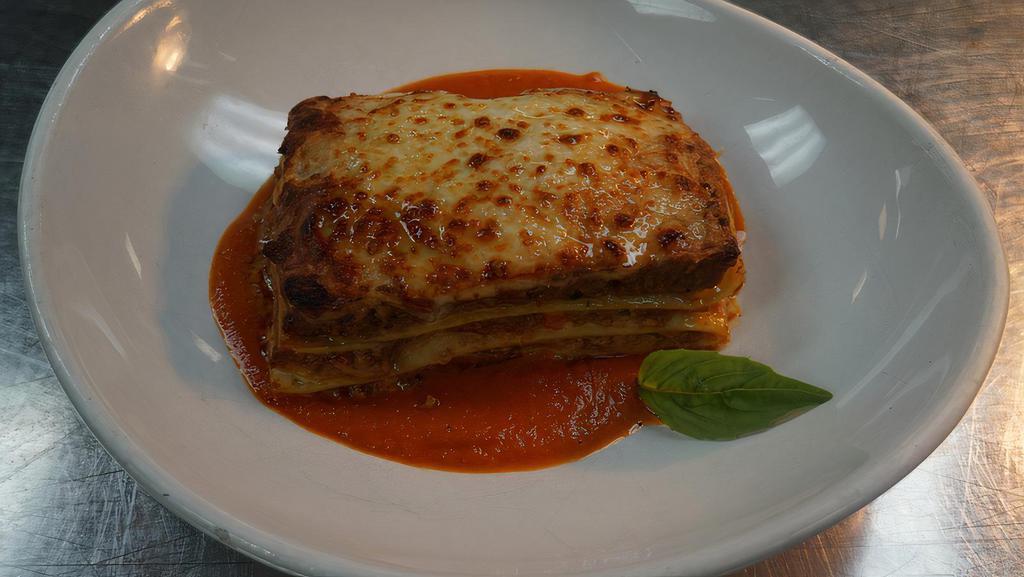 Lasagna “All’Emiliana” · Baked pasta layered with meat sauce, béchamel, mozzarella and parmesan cheese