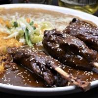 Pork Shanks En Mole · Served with your choice of delicious sweet or spicy salsa called mole sauce, rice, beans and...