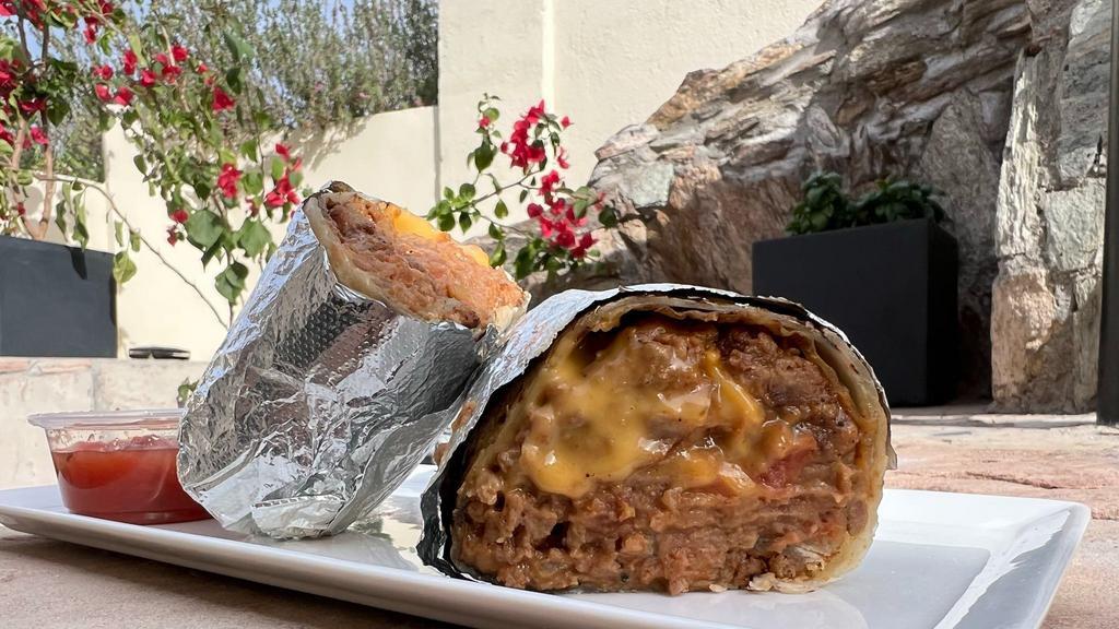 House Burrito · Warm tortilla filled with vegan beef, refried beans, pico de gallo and melted vegan cheese.  Served with salsa on the side.
