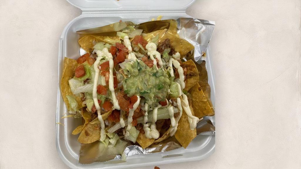 Nachos Jalisco · A bed of Corn Tortillas, topped with your choice Meat, Cheese Dip, Lettuce, Tomatoes, Sour Cream and Guacamole