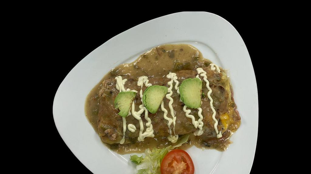 Pueblo Omelette · Bacon, Ham, Barbacoa, Onion, Monterrey and Cheddar Cheese and Smothered in Green Chile and Sour Cream, Garnished with Avocado Slices