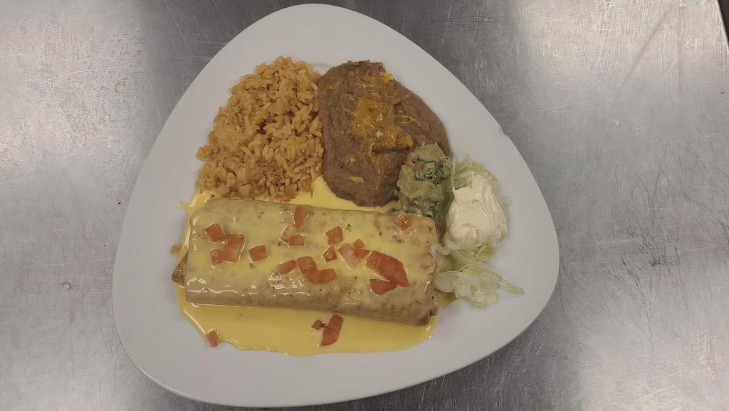 Chimichanga Tex-Mex · Deep fried burrito with beans, cheddar cheese and your choice of Meat inside, topped with cheese dip and diced tomatoes. Garnished with lettuce and tomatoes, served with rice and beans on the side.