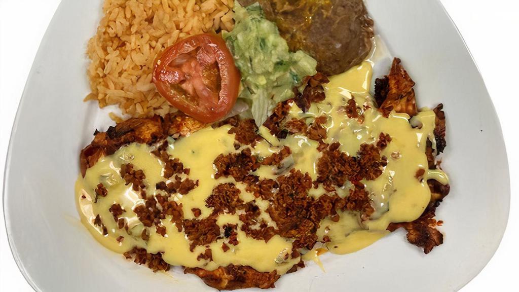 Chori-Pollo · Grilled Adobado Chicken Breast, topped with our Home Mede Chorizo and Con Queso Sauce (Home Made Cheese Dip), served with Rice, Beans, garnished with lettuce, tomatoes and guacamole and your choice of Tortillas