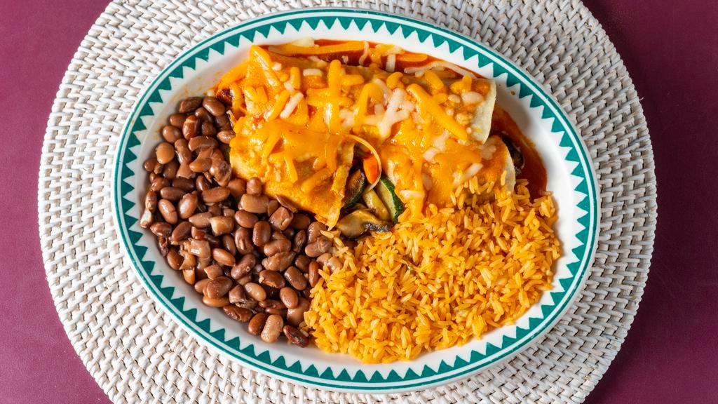 Veggie Enchilada (2 Enchilada) · A soft corn tortilla filled with sautéed zucchini, mushrooms, bell pepper, carrots and onions. Covered in our home made red sauce and melted cheddar jack cheese. Served with rice and whole pinto beans.