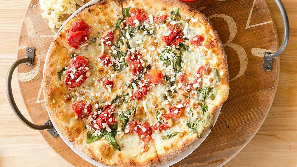 White Pizza · Fresh spinach, pomodoro tomatoes, mozzarella, garlic, alfredo sauce, topped with feta.