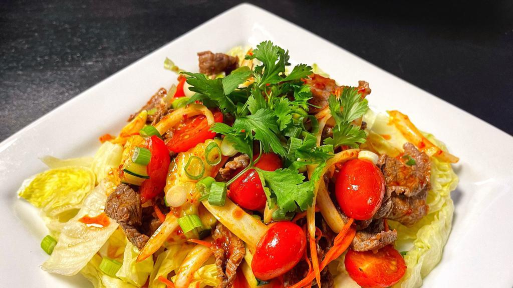 Thai Beef Salad · Strips of beef marinated in lime juice, chili, onions, cilantro, carrots, cucumbers, tomatoes, and served on a bed of lettuce.