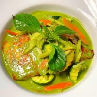 Salmon Curry · Grilled salmon in green curry with zucchinis, bamboo shoots, carrots, and basil leaves.