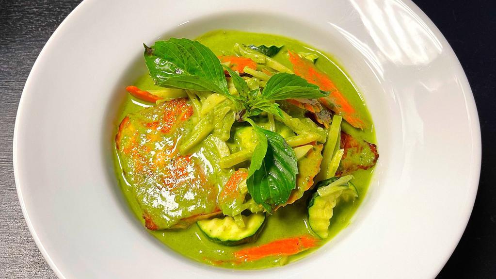 Salmon Curry · Grilled salmon in green curry with zucchinis, bamboo shoots, carrots, and basil leaves.