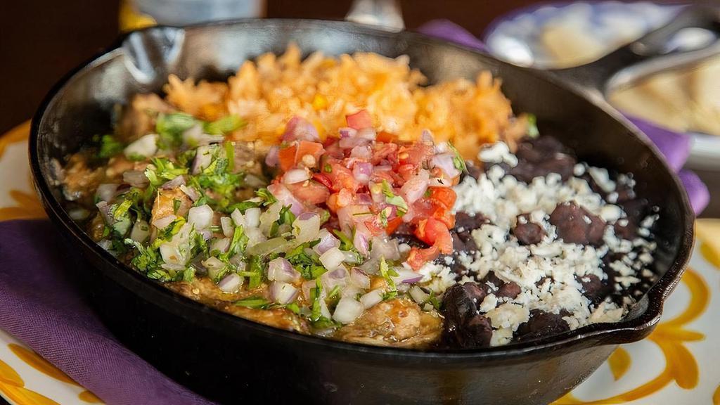 Chile Verde Entrada · Slow-cooked tender pork in a poblano pepper and tomatillo sauce. Topped with diced red onions and fresh cilantro. Served with fresh hand-pressed corn tortillas, Mexican-style rice and epazote black beans.
