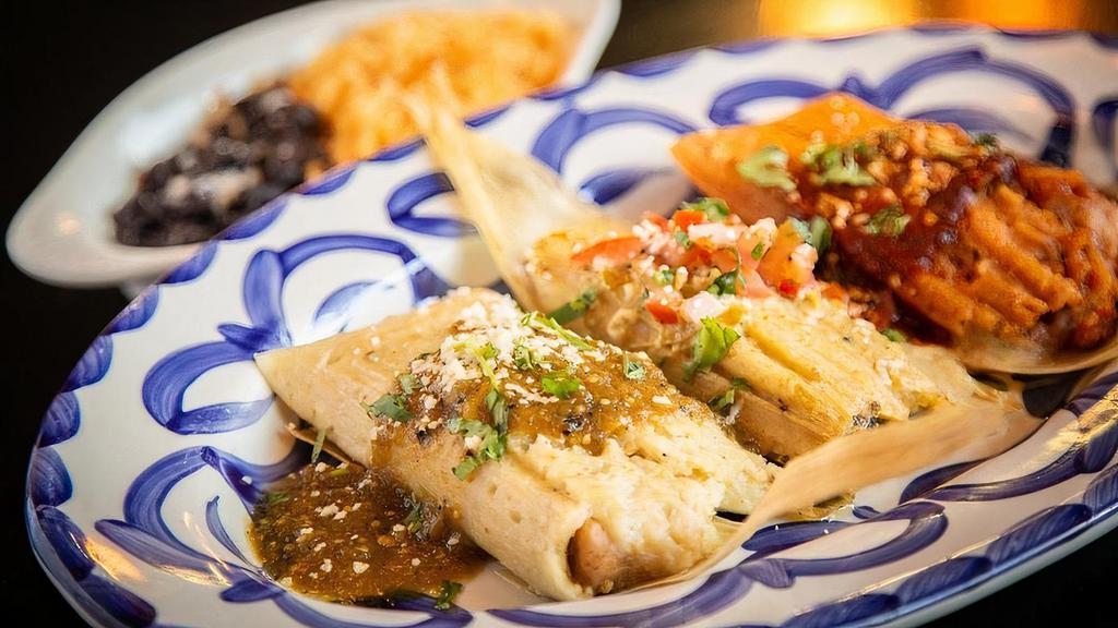 Tamale Trio · Combinations of our Traditional tamales. Pork chile verde topped with roasted tomatillo salsa, chicken in red salsa topped with a three pepper red sauce, vegetarian with Oaxaca cheese and topped with our Queen's cream sauce. . Served with Mexican-style rice and epazote black beans.