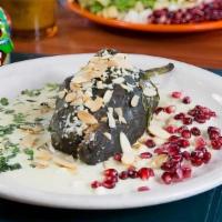 Chiles En Nogada · A roasted poblano pepper filled with chicken, apples, pears, dried apricots, golden raisins,...