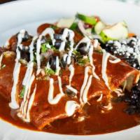 California Enchiladas · Creamy Oaxaca and cotija cheese blend. Topped with our homemade three-chile red sauce, black...