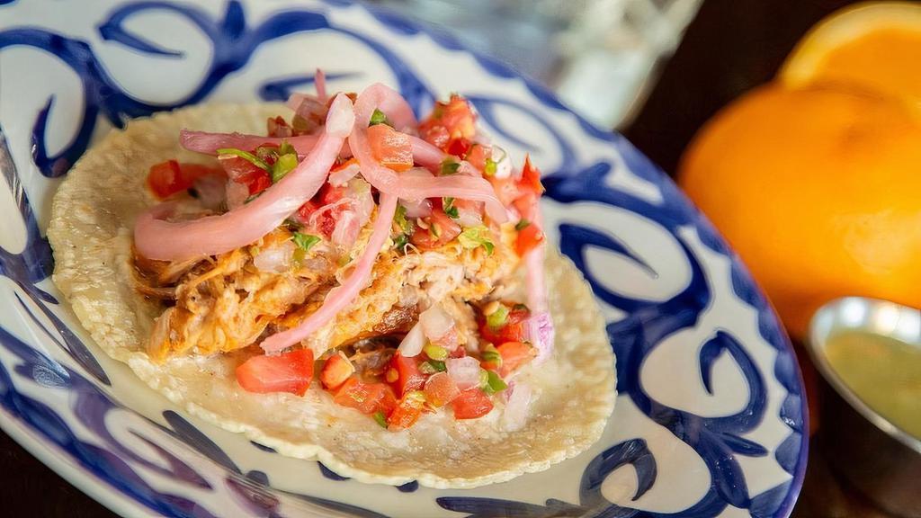 Cochinita Pibil Taco · The Queen's acclaimed pork marinated in sour orange and achiote paste. . Topped with pickled red onions and home-made pico de gallo.