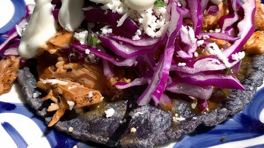 Tacos De Tinga · Shredded chicken sauteed with onions, roasted tomatoes and chipotle sauce.. Topped with cabbage, queso fresco, cilantro and crema fresca.. Served on a blue Corn tortilla.
