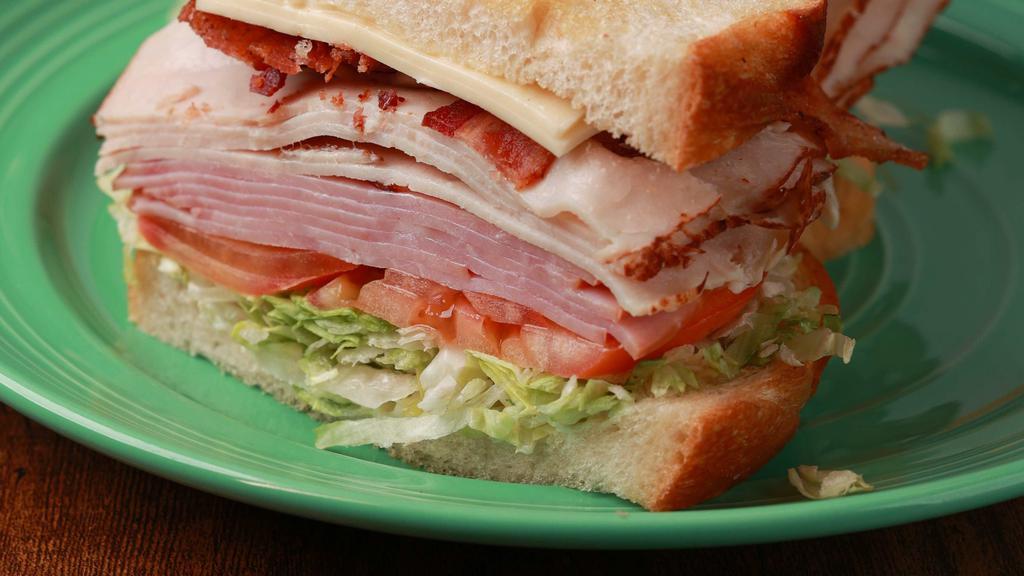 Deli Club Sandwich · Turkey, ham, bacon, white American cheese, lettuce, tomato, onion, and mayo on sourdough bread.