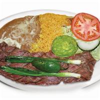 Carne Asada · Skirt steak seasoned and grilled to perfection! Served with rice, beans, salad, Guacamole, a...