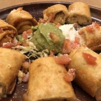 Chicken Taquitos · Two rolled flour tortillas stuffed with chicken and jack cheese, served crispy. Garnished wi...