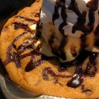 Skillet Cookie · A giant chocolate chip cookie served in a super hot cast iron skillet. Topped with a scoop o...