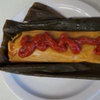 Chicken Tamales · Wrapped with banana leaves and garnished with tomato sauce.
