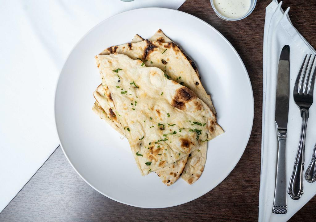 Garlic Naan (1 Pc.) · The perfectly proportioned flavor of garlic in freshly baked wheat bread in traditional clay oven (tandoor).