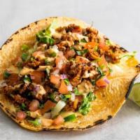 Tejano Style Taco · Impossible ™ tex-mex style taco meat,  topped with queso sauce, shredded lettuce, cilantro, ...