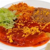 Chiles Rellenos · Two chiles rellenos smothered with enchilada sauce, lettuce, cheese, and tortillas on the si...