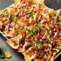 Brisket Nachos · Stacked and loaded with beef brisket, cheddar jack cheese, Pale Ale Queso, lime sour cream, ...