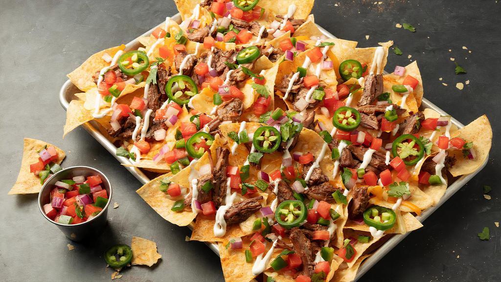 Brisket Nachos · Stacked and loaded with beef brisket, cheddar jack cheese, Pale Ale Queso, lime sour cream, pico de gallo and fresh jalapeños