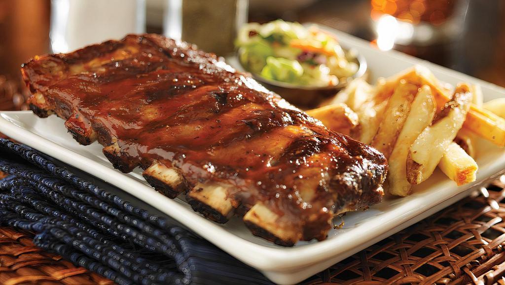 Slow Roasted Baby Back Ribs · Dry-rubbed, slow-roasted baby back pork ribs, brushed with a sweet and tangy BBQ sauce. Served with jalapeno coleslaw and Parmesan fries. in a sweet and tangy BBQ sauce. Served with jalapeno coleslaw and Parmesan fries.
