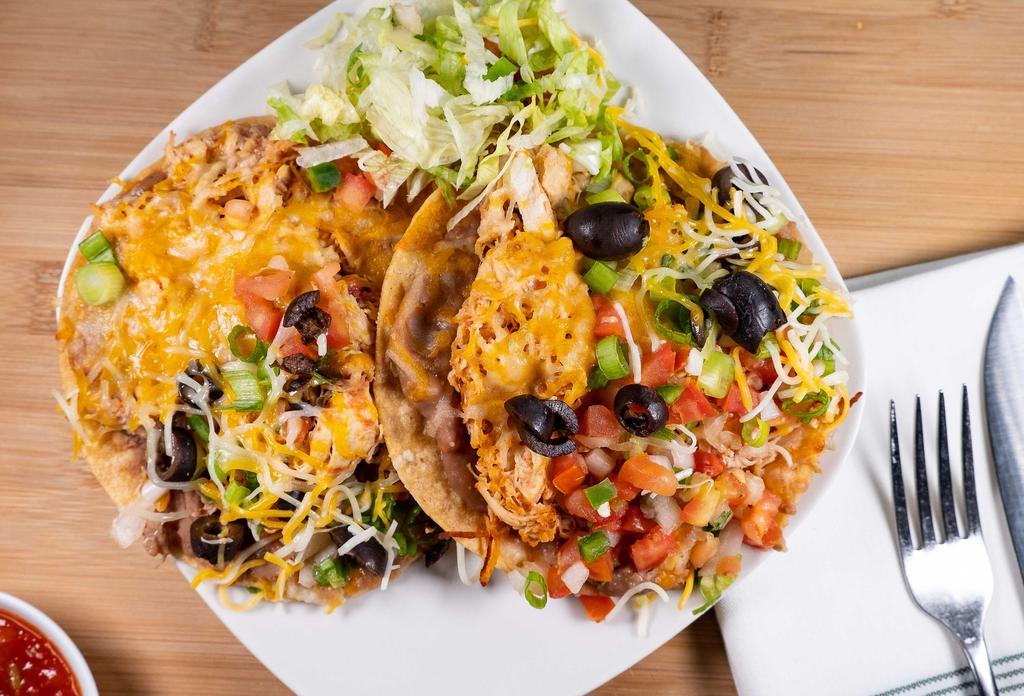 Tostadas · Two flat corn tortilla shells layered with refried beans and your choice of meat. Topped with shredded jack cheese, pico de gallo, black olives, and green onions.