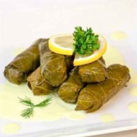 Dolmades · Grape leaves stuffed with seasoned ground beef and herbs served with avgolemono sauce and ri...