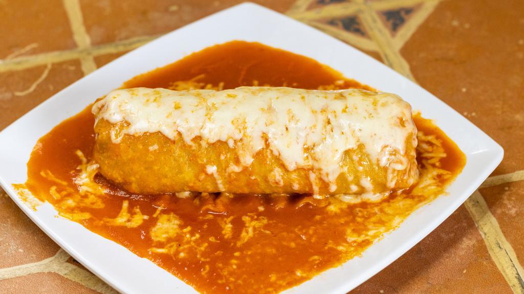 Burrito Mojado / Wet Burrito · Enchilada stye burrito with choice of meat rice beans onion hot sauce covered with enchilada sauce topped with cheese.