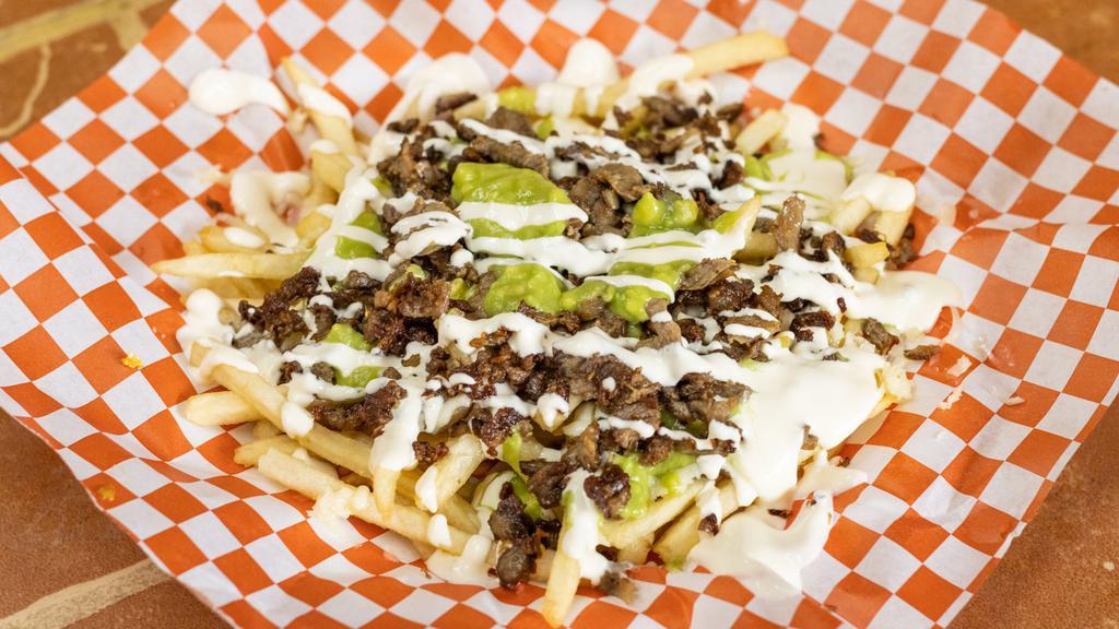 Carne Asada Fries · French fries topped with refried beans meat cheese guacamole sour cream.