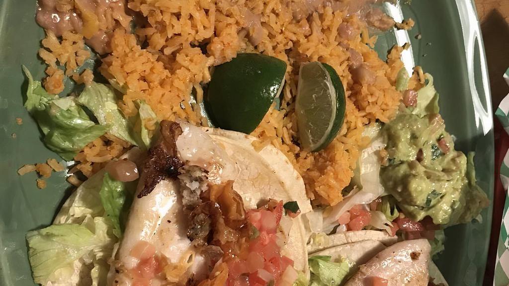 #17 Fish Tacos · Two grilled fish tacos topped with lettuce, pico de gallo, and tartar sauce. Served with rice and beans.