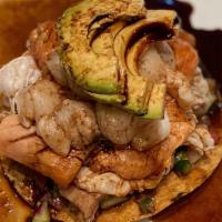 Tostada La Negra · Shrimp cooked in lime over a bed of avocado and mayo Topped with cooked shrimp  and a black ...
