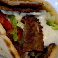Greek Gyro Sandwich · Thinly sliced gyro meat on a grilled pita, veggies, & tzatziki sauce.