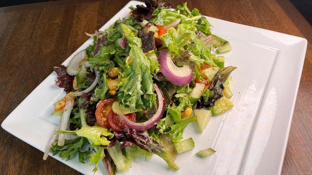 Vegan Chopped Salad · Spring greens, cherry tomato, avocado, red onion, cucumber, spiced roasted cashews, golden balsamic dressing.