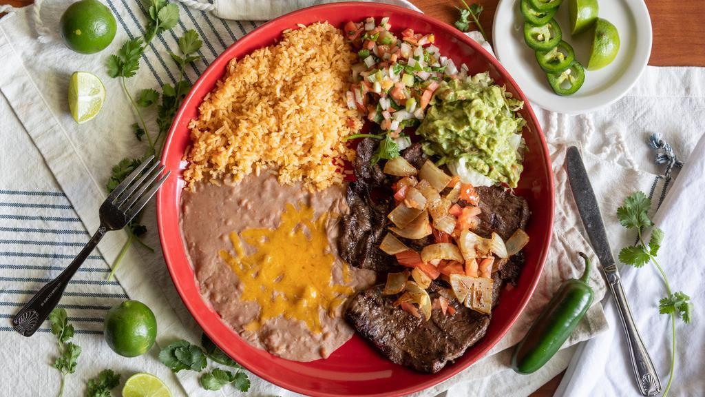 Carne Asada · 10 ounces of thinly cut broiled outside skirt steak, broiled and seasoned, topped with sautéed onions and tomatoes. Served with pico de gallo and guacamole. Served with rice, beans (refried, whole, or black), and tortillas.