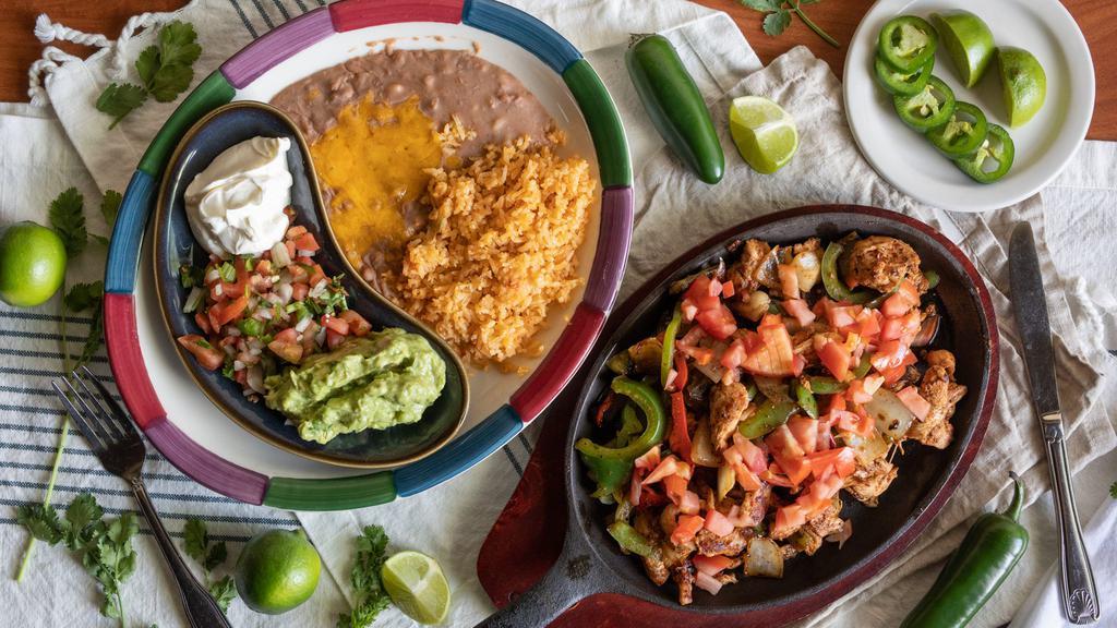 Chicken Fajitas · Served on a hot skillet, with sautéed bell peppers, onions, and diced tomato. Served with rice, beans, pico de gallo, sour cream, guacamole, and tortillas.