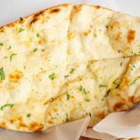 Naan · Traditional tear drop shaped soft flat bread baked in tandoor oven.