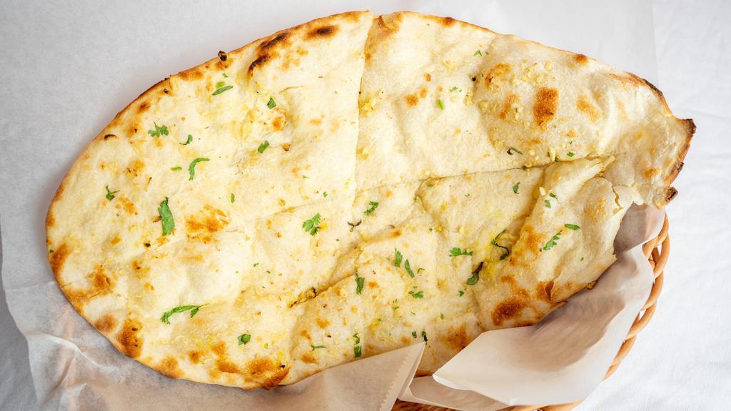 Naan · Traditional tear drop shaped soft flat bread baked in tandoor oven.